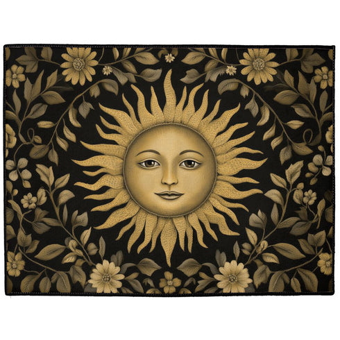 Handcrafted celestial doormat featuring an antique gold sun face with knowing eyes, surrounded by botanical motifs against a deep charcoal background with elegant black trim.