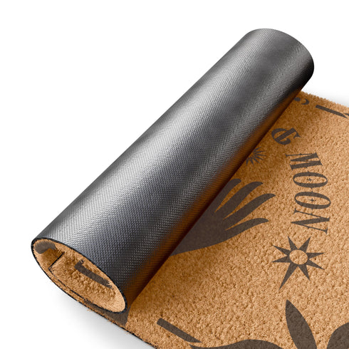 Natural coir doormat featuring black silhouettes of two open hands reaching toward a crescent moon and sun, surrounded by celestial and botanical details. The phrase Shielded by Sun & Moon is hand-stenciled above, with a non-slip vinyl backing for outdoor use.