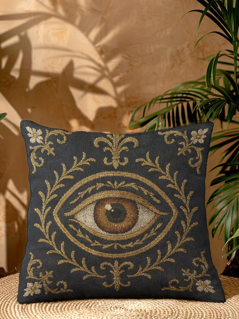 A square woven tapestry pillow in charcoal grey and metallic gold thread, embodying a premium, artisan feel. The central design features a realistic, all-seeing evil eye, a nod to mystical home decor, encircled by ornate Victorian botanical flourishes. This combination of protective symbolism and dark naturalism elements is ideal for Whimsigoth, Gothic, and Dark Academia aesthetics. The luxurious, double-sided piece of functional art is perfect as a statement pillow.