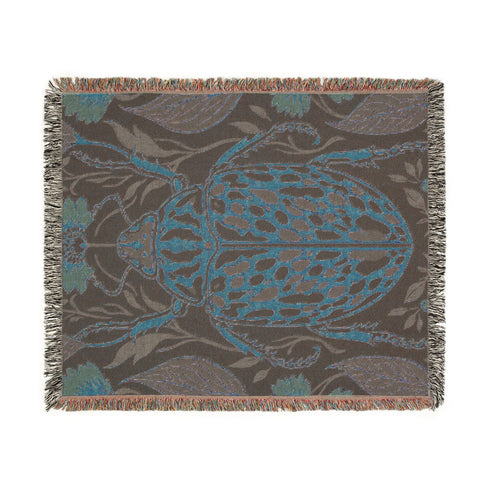 Jacquard woven 100% cotton blanket from Grimoire and Goblet featuring a detailed central beetle entomology motif and vintage botanical floral accents. The textile displays a rich woven texture with a fringe border in a dark academia palette of charcoal black, ochre, and rust. This heirloom-quality gothic tapestry functions as a decorative wall hanging or luxury throw for moody library and study interiors, showcasing high-fidelity thread-work and the brand's sorcerous aesthetic.