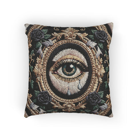 A square woven tapestry throw pillow by Grimoire and Goblet featuring a striking gothic design. The central motif is a large, detailed eye with a teal iris and light blue teardrops, set against pale skin. This eye is encased in an ornate, gold-toned baroque oval frame. The background is deep black, adorned with dark mauve roses and muted green foliage in the corners. The texture is a rich weave.
