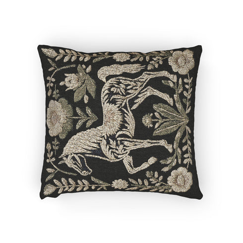 A premium, artisan-woven accent pillow from Grimoire and Goblet. The pillow is 17x18 and features a highly detailed, double-sided jacquard design on a deep black background. The artwork, woven in neutral gold, ecru, and muted olive threads, depicts a mystical, folkloric horse. This central horse figure is surrounded by a lush, symmetrical border of botanical flowers and leaves. The style is evocative of a medieval tapestry, perfect for dark academia, gothic, or arcane-themed decor.