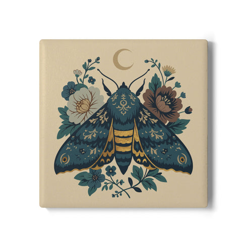Square ceramic coaster, 4x4 inches, with cork backing. Cream tile features a luna-style moth with crescent moon and botanical florals in teal, blue, and gold. Smooth printed surface; clean, flat illustration. Celestial moth coaster for witchy, cottagecore décor and gifting. Square ceramic drink coaster with cork base, luna moth and moon design.