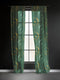 Sheer forest green curtain panel featuring repeating pattern of golden suns and silver moons with radiating lines, creating an elegant celestial motif against translucent fabric.