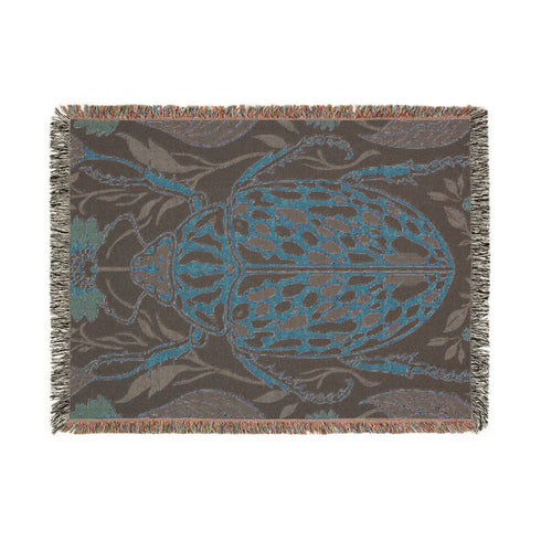 Jacquard woven 100% cotton blanket from Grimoire and Goblet featuring a detailed central beetle entomology motif and vintage botanical floral accents. The textile displays a rich woven texture with a fringe border in a dark academia palette of charcoal black, ochre, and rust. This heirloom-quality gothic tapestry functions as a decorative wall hanging or luxury throw for moody library and study interiors, showcasing high-fidelity thread-work and the brand's sorcerous aesthetic.