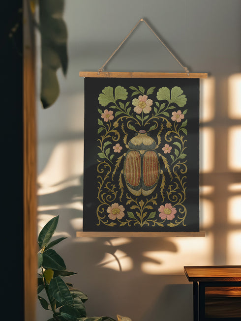 26x36 inch vertical wall tapestry printed on silky polyester fabric, featuring a detailed embroidered-style beetle surrounded by pink and green florals and curling botanical vines on a black background, with wooden hanger and twine at top and bottom. Art nouveau, vintage-inspired, cottagecore, gothic decor.
