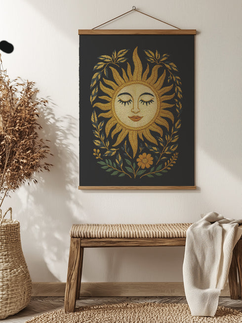 26x36 vertical tapestry featuring a feminine sun face surrounded by golden leaves and florals on a black background. Comes with stained wooden top and bottom dowels and natural twine for hanging. Made of silky polyester fabric with a smooth finish. Ideal for bohemian, celestial, or spiritual home decor themes.