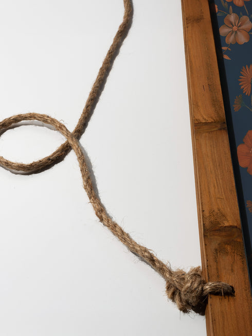 Large wall tapestry featuring a detailed rabbit portrait surrounded by copper and pink flowers on a deep teal background, mounted on wooden dowels with twine for hanging.