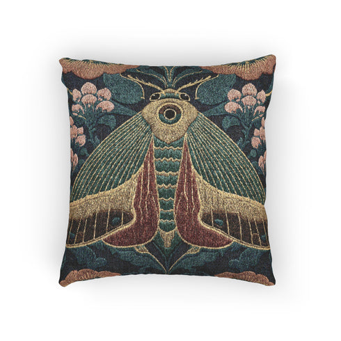 A Grimoire and Goblet woven tapestry pillow featuring a large, symmetrical Oleander Hawk Moth design. The moth has ochre and rust-colored wings with a distinct central eye marking on the thorax. It is set against a deep petrol teal background and flanked by stylized Arts and Crafts floral patterns in dusty rose and sage green. The texture is thick and woven, not printed, showcasing intricate thread details.