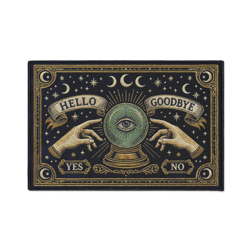 Grimoire and Goblet witchy doormat featuring a deep navy background with antique gold faux embroidered design of a crystal ball with central eye, surrounded by crescent moons, stars, and pointing hands, with ornate border and banner details, rectangular entryway rug with black trim and non-slip backing, mystical occult home decor mat for indoor or covered outdoor use