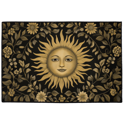Handcrafted celestial doormat featuring an antique gold sun face with knowing eyes, surrounded by botanical motifs against a deep charcoal background with elegant black trim.