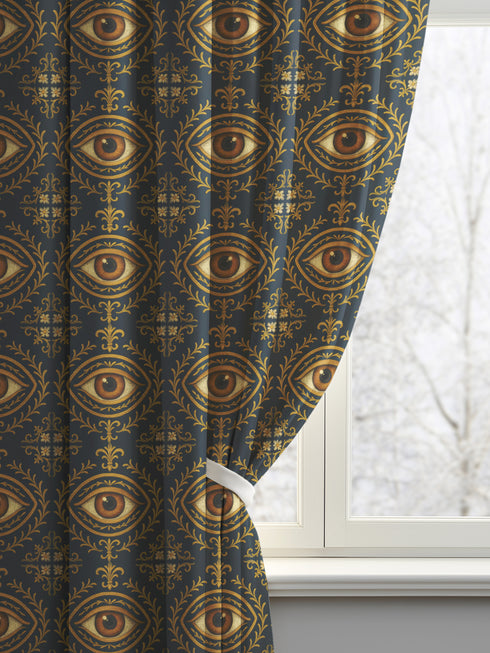 A single panel of a heavyweight blackout curtain with a rich, satiny texture. The design features a repeating pattern of a realistic, all-seeing evil eye, each framed within an ornate, golden Victorian botanical flourish on a dark charcoal background. This mystical art is ideal for Dark Academia, Gothic, and Witchy interior aesthetics, providing both a dramatic statement piece and functional light-blocking for a bedroom, library, or sacred space.