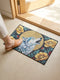 Grimoire and Goblet rectangular doormat featuring a faux embroidery style printed design of a howling wolf with blue and ivory fur, centered in front of a textured antique gold circular moon disc, surrounded by large golden yellow flowers, teal leaves, and small red berry accents on a dark charcoal background. Entryway rug with black trim, non slip backing, and botanical nature inspired mystical design.