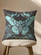 A decorative pillow cover featuring a large Luna moth illustration in seafoam green on a smoke gray background, surrounded by botanical flourishes and flowers in a symmetrical design.