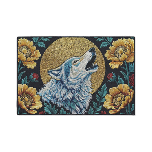 Grimoire and Goblet rectangular doormat featuring a faux embroidery style printed design of a howling wolf with blue and ivory fur, centered in front of a textured antique gold circular moon disc, surrounded by large golden yellow flowers, teal leaves, and small red berry accents on a dark charcoal background. Entryway rug with black trim, non slip backing, and botanical nature inspired mystical design.