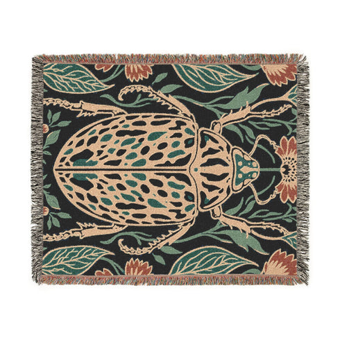 Jacquard woven 100% cotton blanket from Grimoire and Goblet featuring a detailed central beetle entomology motif and vintage botanical floral accents. The textile displays a rich woven texture with a fringe border in a dark academia palette of charcoal black, ochre, and rust. This heirloom-quality gothic tapestry functions as a decorative wall hanging or luxury throw for moody library and study interiors, showcasing high-fidelity thread-work and the brand's sorcerous aesthetic.