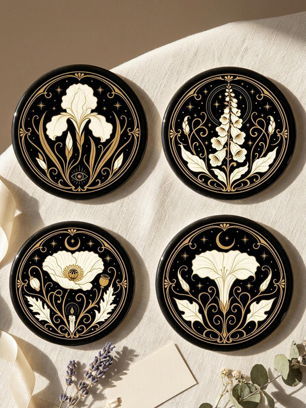 A set of four round 4-inch ceramic coasters featuring a glossy 2D flat-printed Art Deco botanical design. Each coaster displays a different cream-colored flower including a moonflower, foxglove, poppy, and iris, set against a solid black background. The floral motifs are framed by intricate gold linework, crescent moons, four-pointed stars, and mystical symbols like a candle and an all-seeing eye. The coasters have a smooth white edge and are finished with a natural brown cork backing.