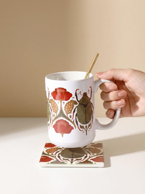 A luxury gift set featuring a matching ceramic mug and square coaster with a vintage entomology design. The artwork depicts a vibrant green Scarab beetle with iridescent wings, surrounded by dark moody floral botanicals in rust and ochre, set against a creamy background in a Victorian naturalist style. The mug is 15oz with a large handle and full wrap design. The coaster is glazed ceramic tile with a cork backing. Perfect for Dark Academia and Grimoire and Goblet gothic home decor.