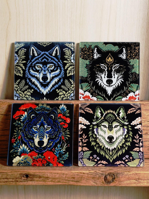 Set of 4 square tempered glass coasters featuring a mystical wolf design on a black background. High-gloss finish with non-slip rubber feet. Dark Academia and Whimsigoth aesthetic home decor. Close-up detail shows grey wolf fur texture and amber eyes. Durable drinkware protection for wooden tables. Grimoire and Goblet gothic luxury barware accessory for coffee tables and desks. Heat resistant glass surface with polished edges.