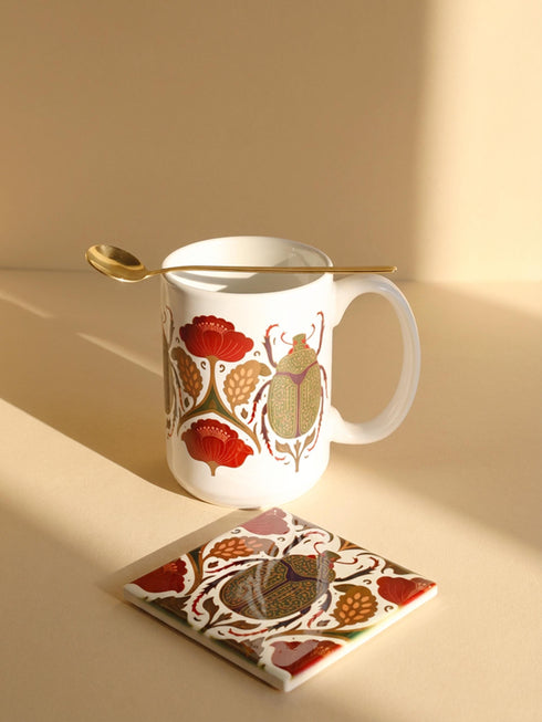 A luxury gift set featuring a matching ceramic mug and square coaster with a vintage entomology design. The artwork depicts a vibrant green Scarab beetle with iridescent wings, surrounded by dark moody floral botanicals in rust and ochre, set against a creamy background in a Victorian naturalist style. The mug is 15oz with a large handle and full wrap design. The coaster is glazed ceramic tile with a cork backing. Perfect for Dark Academia and Grimoire and Goblet gothic home decor.