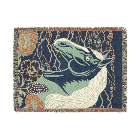 A Grimoire and Goblet woven cotton blanket featuring a large, stylized horse head in sage green and teal against a deep midnight navy background with wave patterns. The bottom edge features woven floral motifs in rust orange and deep plum. The design is a jacquard weave, not printed, with visible thread texture and multi-colored fringe edges. Chinoiserie and Art Nouveau style equestrian tapestry throw.