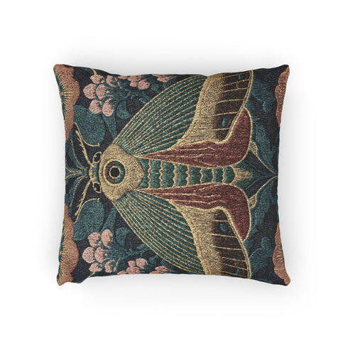 A Grimoire and Goblet woven tapestry pillow featuring a large, symmetrical Oleander Hawk Moth design. The moth has ochre and rust-colored wings with a distinct central eye marking on the thorax. It is set against a deep petrol teal background and flanked by stylized Arts and Crafts floral patterns in dusty rose and sage green. The texture is thick and woven, not printed, showcasing intricate thread details.