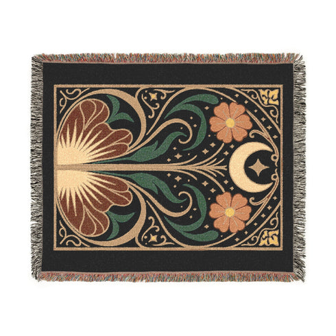 A luxurious, intricately woven jacquard blanket from Grimoire and Goblet. The design is a symmetrical Art Nouveau botanical pattern on a dark teal background. A central stem with green leaves swirls upwards, flanked by two large, rust-orange flowers. At the top, a golden crescent moon and star sparkle. A fan-like, sun-inspired motif rests at the base. The entire piece, crafted from 100% cotton, is framed by a decorative gold border and a multi-colored fringe.