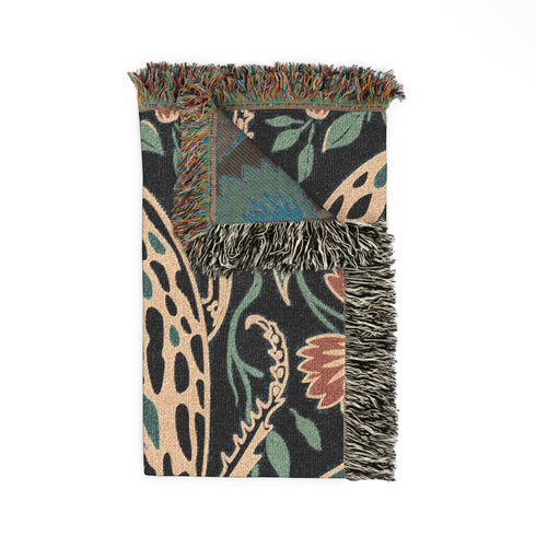 Jacquard woven 100% cotton blanket from Grimoire and Goblet featuring a detailed central beetle entomology motif and vintage botanical floral accents. The textile displays a rich woven texture with a fringe border in a dark academia palette of charcoal black, ochre, and rust. This heirloom-quality gothic tapestry functions as a decorative wall hanging or luxury throw for moody library and study interiors, showcasing high-fidelity thread-work and the brand's sorcerous aesthetic.