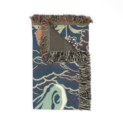 A Grimoire and Goblet woven cotton blanket featuring a large, stylized horse head in sage green and teal against a deep midnight navy background with wave patterns. The bottom edge features woven floral motifs in rust orange and deep plum. The design is a jacquard weave, not printed, with visible thread texture and multi-colored fringe edges. Chinoiserie and Art Nouveau style equestrian tapestry throw.