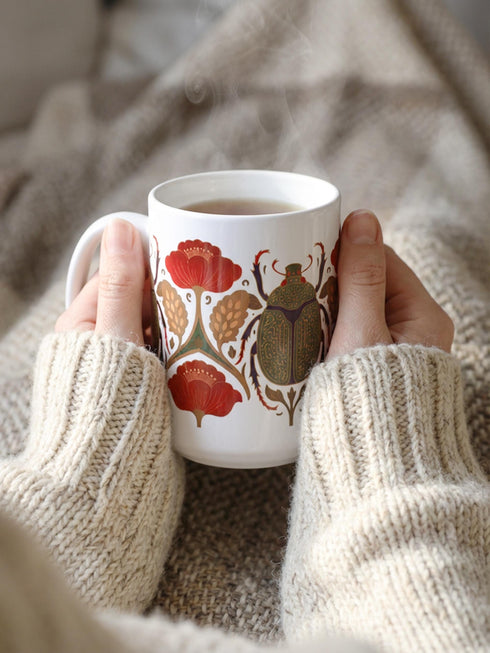 A luxury gift set featuring a matching ceramic mug and square coaster with a vintage entomology design. The artwork depicts a vibrant green Scarab beetle with iridescent wings, surrounded by dark moody floral botanicals in rust and ochre, set against a creamy background in a Victorian naturalist style. The mug is 15oz with a large handle and full wrap design. The coaster is glazed ceramic tile with a cork backing. Perfect for Dark Academia and Grimoire and Goblet gothic home decor.