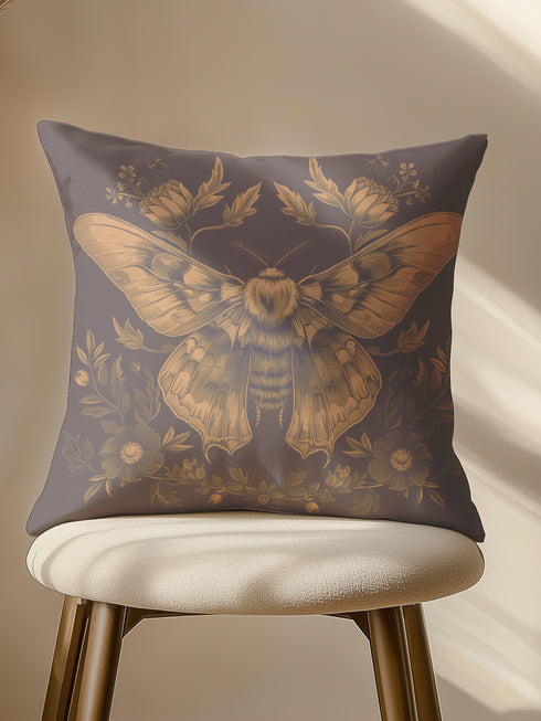 A decorative pillow cover featuring an intricately detailed Luna moth illustration in antique gold on a smoke gray background, surrounded by symmetrical botanical elements including flowers and delicate foliage.