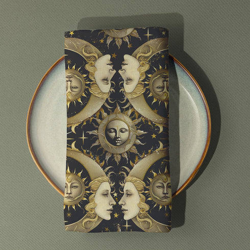 Set of four black cloth napkins with a repeating pattern of golden sun and moon faces, surrounded by swirling flames, craters, and scattered stars.