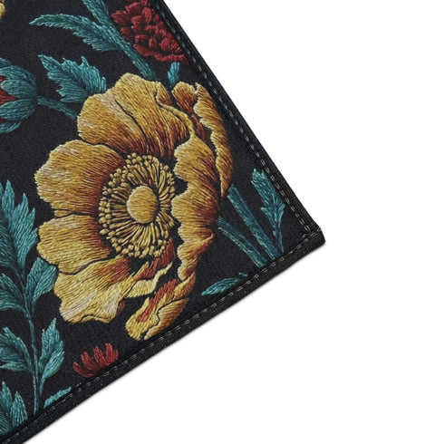 Grimoire and Goblet rectangular doormat featuring a faux embroidery style printed design of a howling wolf with blue and ivory fur, centered in front of a textured antique gold circular moon disc, surrounded by large golden yellow flowers, teal leaves, and small red berry accents on a dark charcoal background. Entryway rug with black trim, non slip backing, and botanical nature inspired mystical design.
