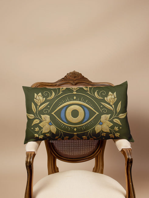 A rectangular lumbar pillow cover in a deep olive green, featuring a prominent All-Seeing Eye design at its center. The eye is rendered in rich gold and royal blue tones, detailed to emulate the intricate texture of fine embroidery. Golden Art Nouveau-style botanical flourishes with leaves and flowers frame the central eye, extending across the linen-feel polyester fabric. This gothic and dark academia style accent cushion is designed for mystical home decor, serving as a protective talisman.