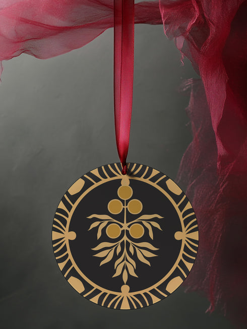 Round metal ornament featuring golden juniper berry branch design with Art Deco-inspired geometric border on black background. 3.5-inch diameter piece with botanical motif and crimson ribbon. Double-sided detailed artwork.