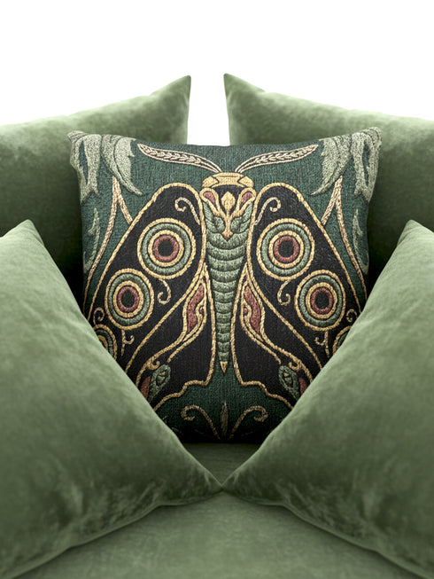 A Grimoire and Goblet heirloom woven pillow featuring a large, symmetrical Art Nouveau Emperor Moth design. The moth is woven in textured threads of midnight black, burnished gold, and rust terracotta against a deep sage forest green background. Four prominent eye-spot patterns adorn the wings, framed by stylized botanical acanthus leaves in the upper corners. Double-sided tapestry fabric with a rich, tactile surface. No printed ink; purely woven structure.