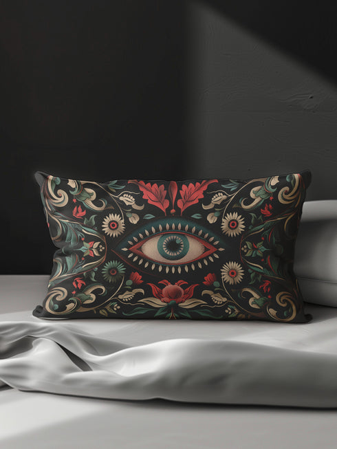 Black lumbar pillow cover featuring an ornate evil eye design with detailed floral motifs in red, cream, and green, framed by gold accents.