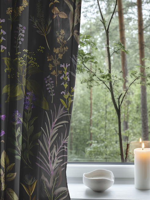Sheer curtain panel featuring an intricate vertical pattern of wild botanicals including purple flowers, golden leaves, and silvery fronds against a dark charcoal background. The design shows detailed herbarium-style illustrations.