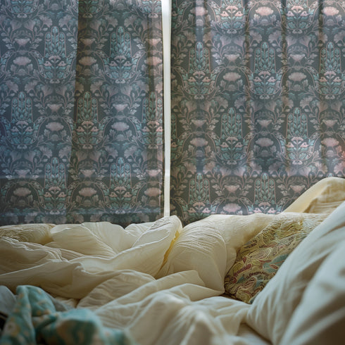 Sheer curtain panel featuring repeating teal hamsa hands with blush pink floral elements on dark gray background. Linen-textured polyester fabric allows filtered light while providing elegant window covering with protective symbolism for bohemian or vintage decor.
