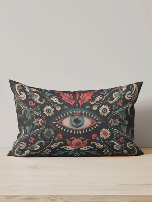 Black lumbar pillow cover featuring an ornate evil eye design with detailed floral motifs in red, cream, and green, framed by gold accents.