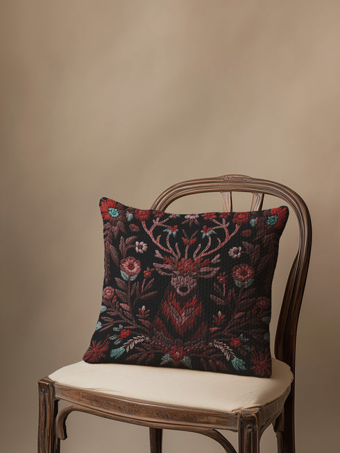 Woven throw pillow featuring an embroidered stag with antlers entwined in red and teal florals, set against a black background.