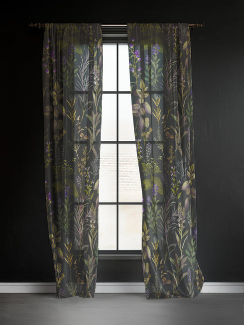Sheer curtain panel featuring an intricate vertical pattern of wild botanicals including purple flowers, golden leaves, and silvery fronds against a dark charcoal background. The design shows detailed herbarium-style illustrations.