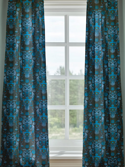 A sheer curtain panel featuring a repeating pattern of stylized owls in luminous blue tones, surrounded by delicate botanical flowers and flourishes on a dark background.