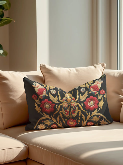 A rectangular black lumbar pillow with a premium linen-feel texture. The pillow features a detailed, tapestry-style Art Nouveau print of a large scarab beetle at its center. The beetle and surrounding symmetrical floral and botanical motifs are rendered in rich colors of antique gold, deep crimson red, and muted teal. This ornate, maximalist design is set against a dark charcoal black background, creating a moody, gothic, & scholarly aesthetic suitable for dark academia or victorian home decor.