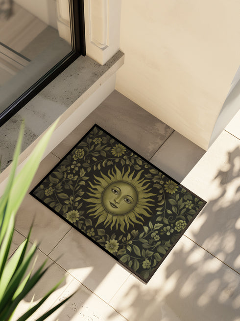 Witchy home décor doormat with an enchanting olive green sun face surrounded by flowing botanicals and foliage on a rich black background, ideal for adding earth-centered mysticism to any entrance.