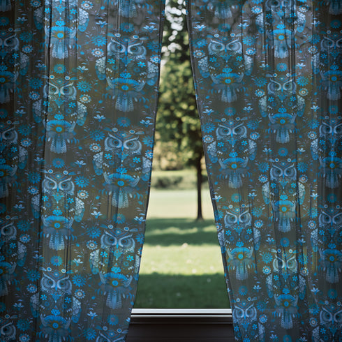 A sheer curtain panel featuring a repeating pattern of stylized owls in luminous blue tones, surrounded by delicate botanical flowers and flourishes on a dark background.