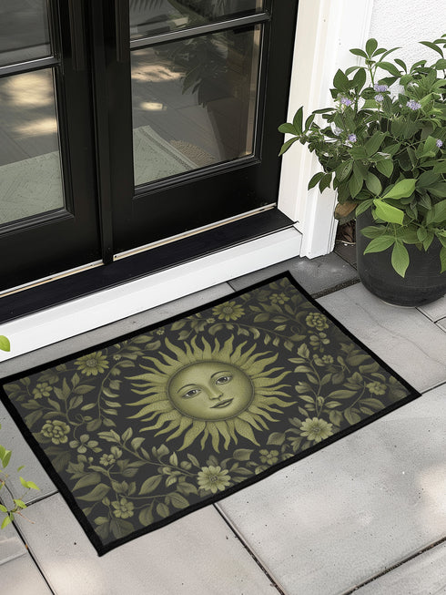 Witchy home décor doormat with an enchanting olive green sun face surrounded by flowing botanicals and foliage on a rich black background, ideal for adding earth-centered mysticism to any entrance.