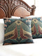 A Grimoire and Goblet woven tapestry pillow featuring a large, symmetrical Oleander Hawk Moth design. The moth has ochre and rust-colored wings with a distinct central eye marking on the thorax. It is set against a deep petrol teal background and flanked by stylized Arts and Crafts floral patterns in dusty rose and sage green. The texture is thick and woven, not printed, showcasing intricate thread details.
