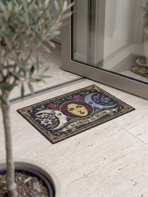 A triple moon doormat featuring the sacred symbol of maiden, mother, and crone, rendered in antique gold on a black ground with botanical detailing—designed for witchy homes, Wiccan spaces, and those drawn to divine feminine symbolism