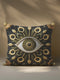 Square pillow cover featuring a central gold embroidered all-seeing eye design, surrounded by ornate botanical and sunflower-inspired motifs in gold, olive, and ochre on a black background. Made from premium linen-feel polyester, double-sided print, hidden zipper closure, available in 18x18 or 22x22 inch sizes, machine washable.